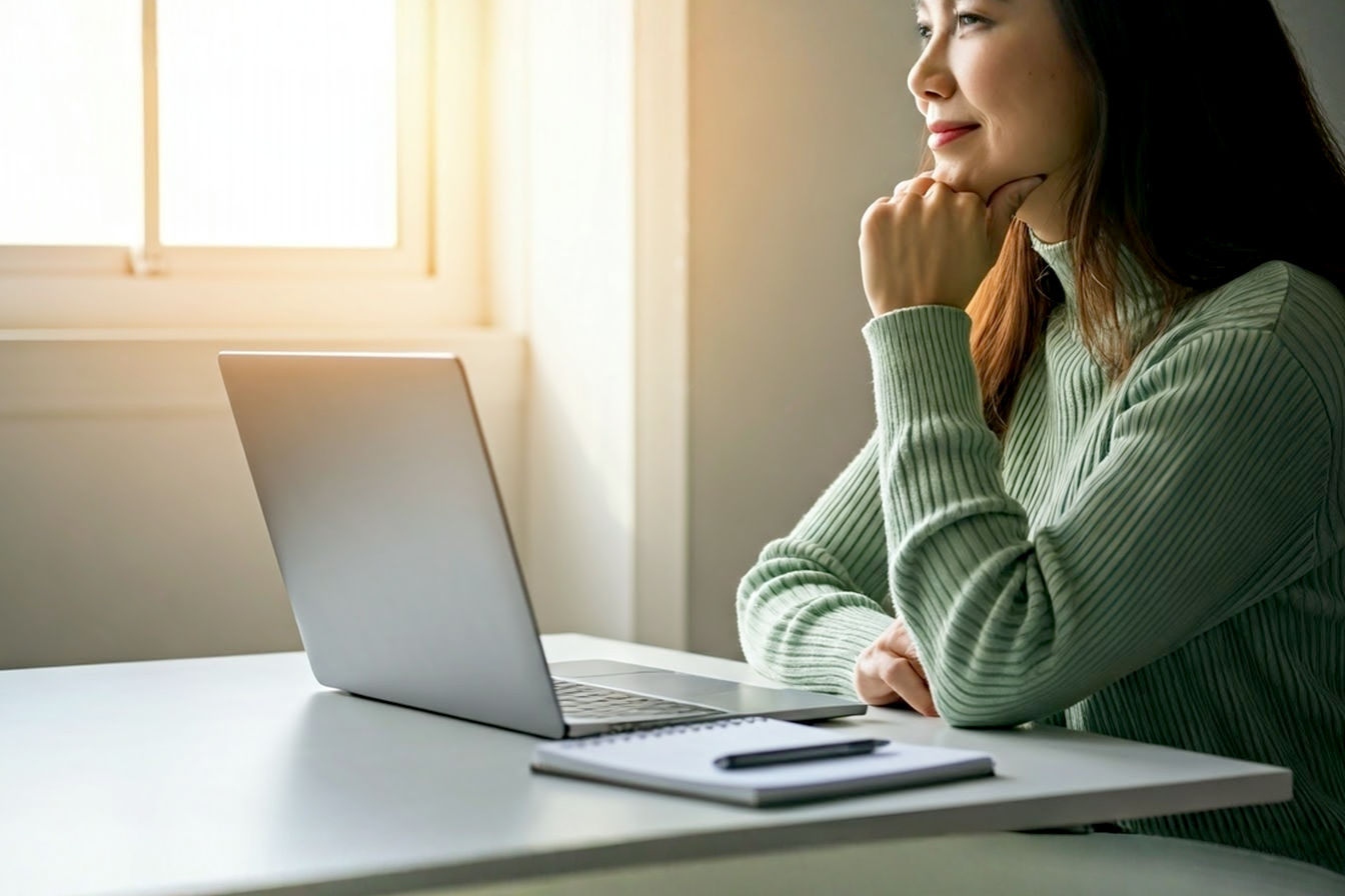 Professional, vibrant, and optimistic photograph. A person is sitting at a clean, modern desk with a laptop open. The laptop screen subtly glows, hinting at online activity. Sunlight streams in from a nearby window, creating a bright and airy feel. The person is looking thoughtfully towards the laptop screen with a slight smile, conveying focus and early success. In the foreground, slightly out of focus, could be a notepad with a simple checklist or a mind map visible. The overall mood should be inspiring, actionable, and tech-savvy, illustrating the theme of starting an online affiliate marketing venture with positive initial results.